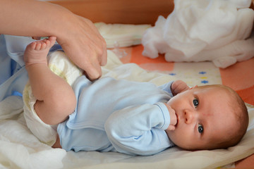 Mother changing the baby's nappy © Dziurek