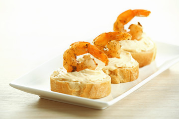 Appetizer canape with shrimp on plate on table close up