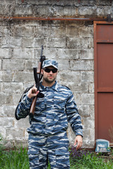 Fototapeta premium Caucasian military man with black sunglasses in urban warfare ho