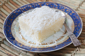 Rice pudding with coconut on blue vintage plate with spoon on wo