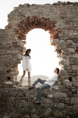 Young couple together in window old rock ruined building