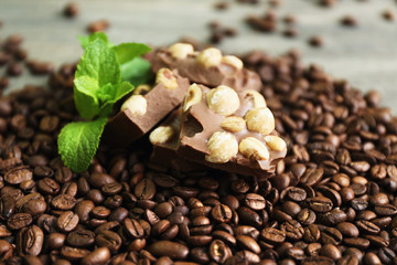 Chocolate with mint and coffee beans on wooden table, closeup