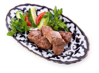 Meat on a grill with vegetables