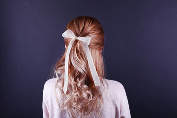 Naklejka premium Female hairstyle with color ribbon on dark background