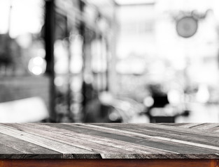 Empty wood table top with coffee shop blur with bokeh background