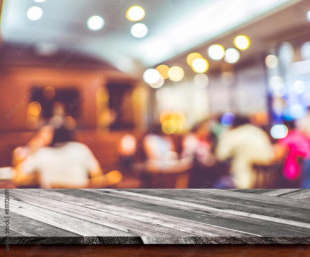 Poster Empty wood table top with restaurant blur with bokeh background