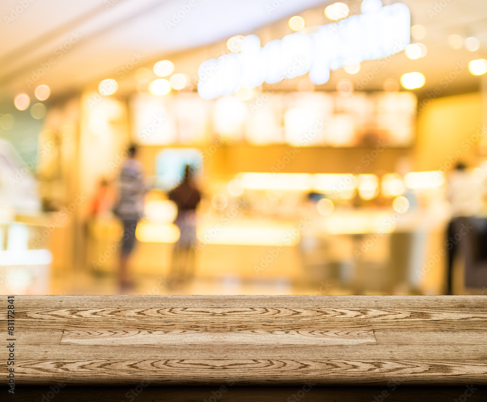 Poster Empty wood table top with coffee shop blur with bokeh background