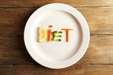 Word DIET made of sliced vegetables in white plate