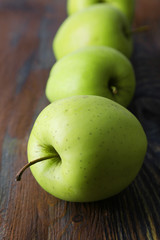 Green apples on wooden background