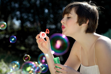Woman blows soap bubbles