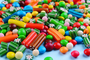 Colorful candies on light blue background