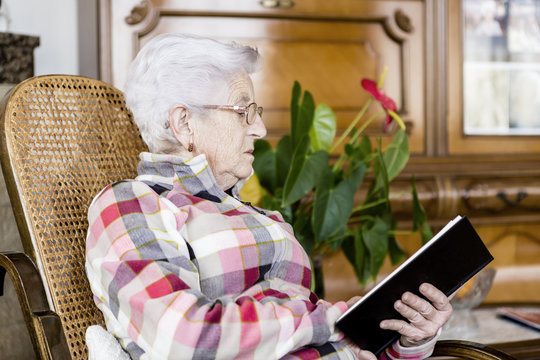 Senior woman reading book relaxed at home