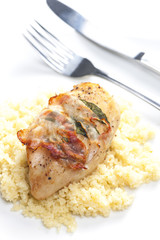 chicken meat on sage baked with bacon and served with couscous