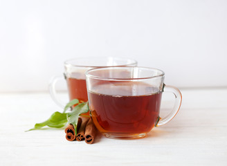 Glass cup of green tea with cinnamon sticks