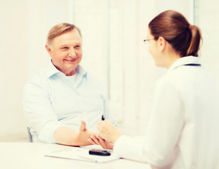 Fototapeta premium female doctor or nurse measuring blood sugar value