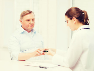 female doctor or nurse measuring blood sugar value