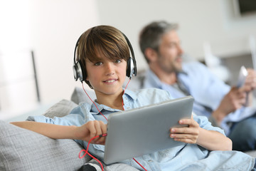 Tenager watching movie on tablet with headphones on