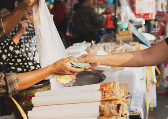 close up of hands giving money at street market