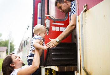 Family with a son travel entering the train.