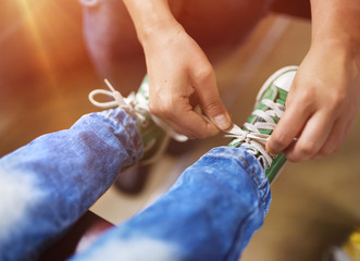 Father tying shoe laces of his son traveling in train.