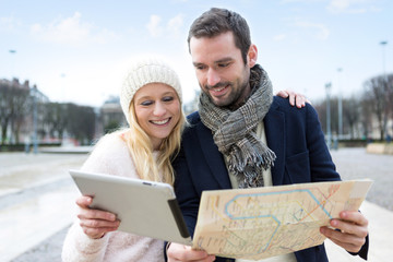 Couple of young attractive tourists watching map
