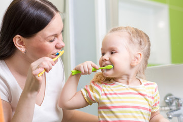 cute mom teaching kid teeth brushing