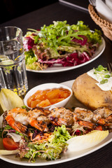 Grilled prawns with endive salad and jacket potato