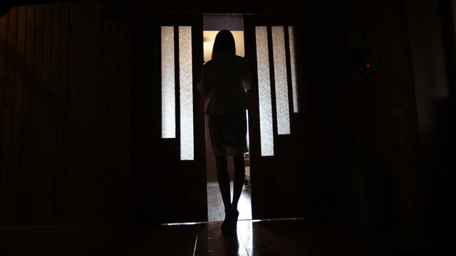 Silhouette of a woman in a doorway front of the window