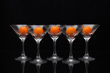 Five glasses of champagne and golf balls