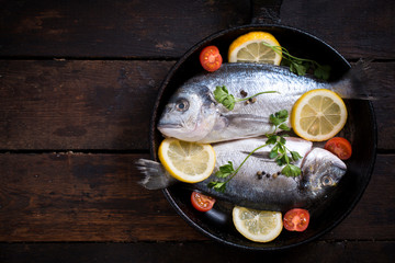 Gilthead fish in pan with ingredients