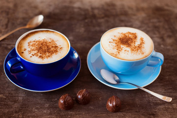 Two cups of coffee on a wooden table background