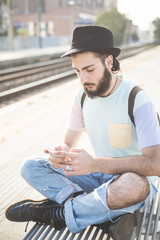 young handsome hipster gay modern man using smartphone