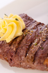 Grilled beef steak topped with butter and rosemary