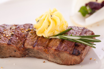 Grilled beef steak topped with butter and rosemary