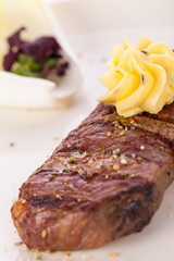 Grilled beef steak topped with butter and rosemary