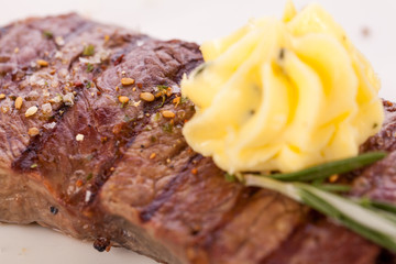 Grilled beef steak topped with butter and rosemary