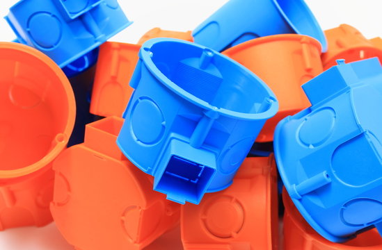 Heap of orange and blue electrical boxes on white background
