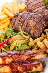 Platter of mixed meats, salad and French fries