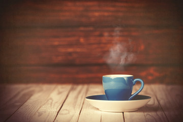 Obraz premium Cup of coffee on wooden table and background.