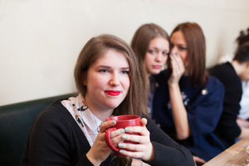 girls gossiping a friend in coffee shop