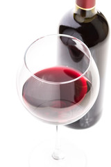 Wineglass with red wine and bottle on white background