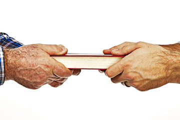 Closeup of mature man´s hand giving a book to his son,conceptua