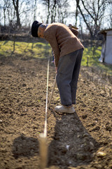 Old farmer with astrakhan hat working
