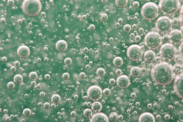 Macro Oxygen bubbles in water on a green background