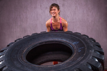 Fit young Woman Doing  Exercise With Tire