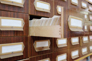 Naklejka na ściany i meble Old wooden card catalog with one opened drawer in library