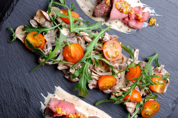 Appetizer with mushrooms, meat and tomatoes