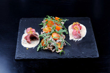 Appetizer with mushrooms, meat and tomatoes