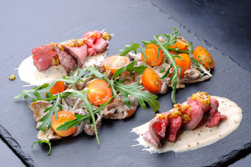 Appetizer with mushrooms, meat and tomatoes