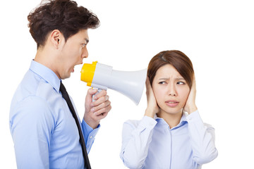 Businessman using megaphone to scream at businesswoman